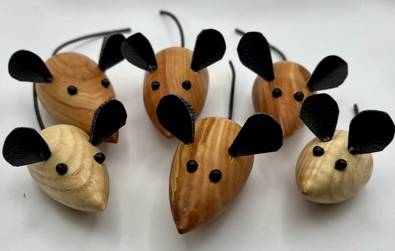 A collection of finished turned wooden mice arranged together in a horde